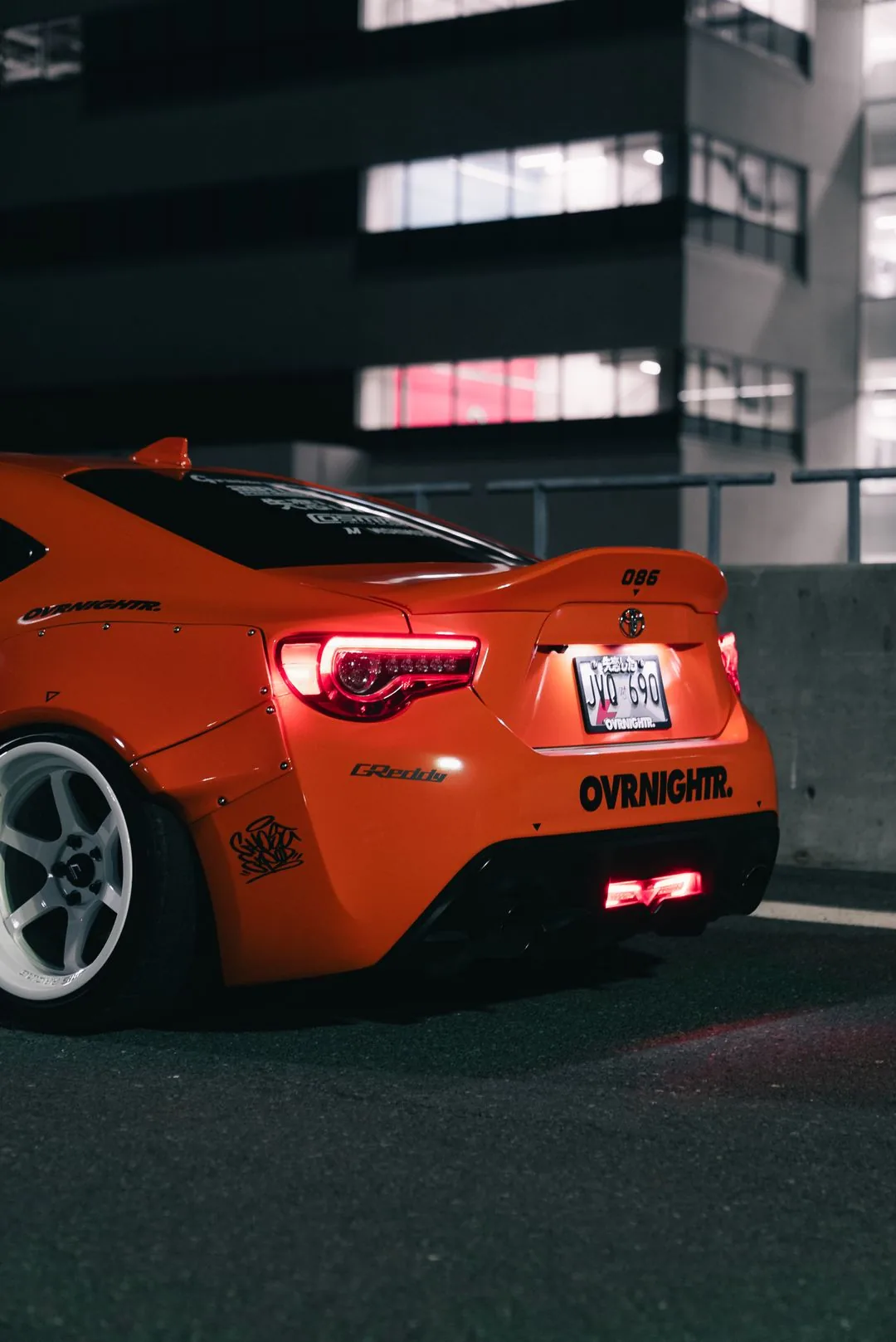 orange sports car in urban night phone wallpaper aesthetic